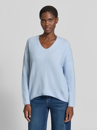 Kobiece model prezentuje sweter z dzianiny z mieszanki wełny z domieszką alpaki, krój regular fit, dekolt w serek, MOS MOSH Strickpullover aus Woll-Mix mit V-Ausschnitt Modell 'THORA', jasnoniebieski, długość tyłu w rozmiarze S: 82 cm, długość rękawów: 46 cm, widok całej sylwetki od przodu.