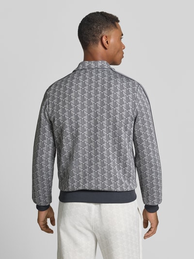 Männermodel trägt Regular Fit Sweatjacke mit Reißverschluss von Lacoste in Grau mit grafischem Muster, mittlere Textur, Ganzkörperansicht Rückansicht.