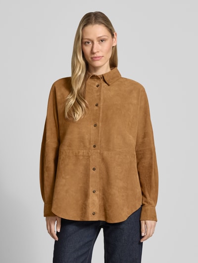 Kobiece modelka ma na sobie Lederjacke aus Lammleder mit abgerundetem Saum od Rich & Royal, skóra jagnięca, prosty krój, kołnierzyk typu kent, listwa guzikowa, szwy działowe, zaokrąglony dół, karmelowy kolor, gładka faktura, widok całej sylwetki z przodu.
