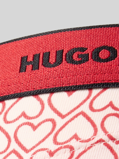 Frauenmodel trägt String aus Baumwoll-Mix Modell 'THONG STRIPE PYP' von HUGO mit grafischem Allover-Muster, elastischem Bund, Nahaufnahme Oberkörper.