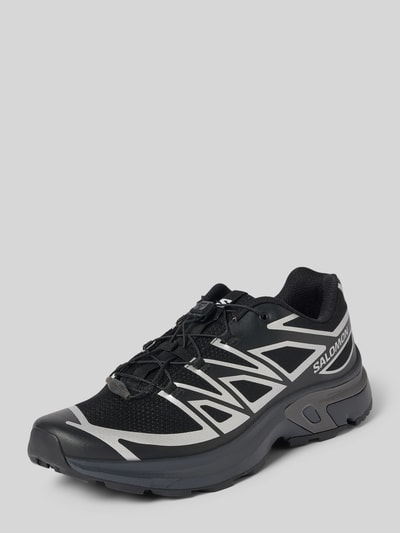 Produktfoto, Sneaker mit profilierter Sohle Modell 'XT-EVR' von Salomon in Schwarz mit silbernen Details, abgerundete Spitze, Schnürung, Logo auf Seite.