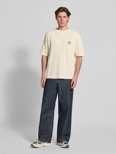 Männermodel trägt Herren T-Shirt mit Strukturmuster Modell 'Nelson' von Carhartt Work In Progress, Reine Baumwolle, Relaxed-Fit, Label-Detail, Rundhalsausschnitt, Rückenlänge bei Größe M 70 cm, Ganzkörperansicht von vorne.