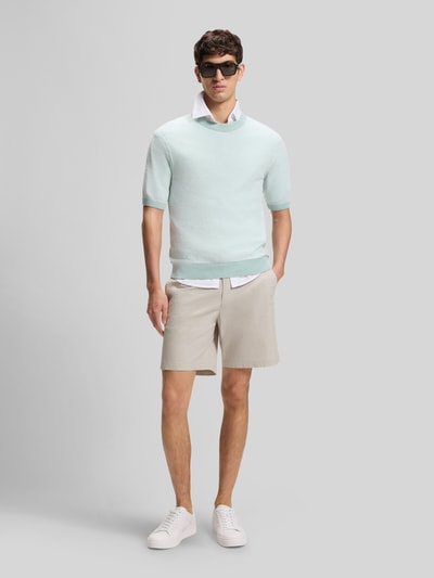 Männermodel trägt Regular Fit Chino-Shorts aus Baumwoll-Mix von BOSS Orange, Optik: Unifarben, seitliche Eingrifftaschen, Ganzkörperansicht von vorne.