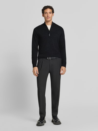Männermodel trägt Regular Fit Troyer aus reinem Kaschmir von FTC Cashmere in Schwarz mit Troyer-Kragen, gerippten Abschlüssen, Ganzkörperansicht von vorne.