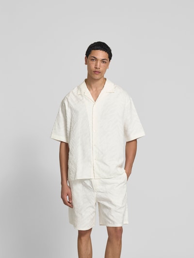 Männermodel trägt Freizeithemd mit Strukturmuster von Kenzo in Creme mit Reverskragen aus Baumwolle, Kurzarm, Ganzkörperansicht von vorne.