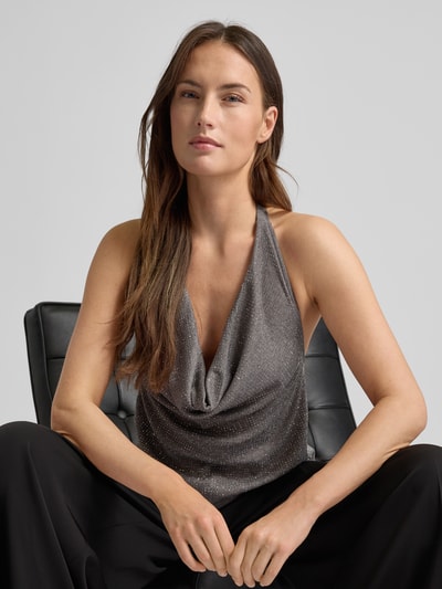 Frauenmodel trägt Blusentop mit Viskose-Anteil Modell 'SPARKLE' von Mango, silberfarbene Strassstein-Optik, Neckholder, Nahaufnahme Oberkörper.