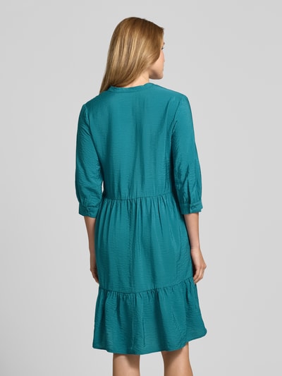 Frauenmodel trägt Relaxed Fit Midikleid aus Viskose-Mix mit Tunika-Ausschnitt von Christian Berg Woman in Türkis, Halbarm, Knopfleiste, Strukturstoff, Ganzkörperansicht Rückansicht, Rückenlänge bei Größe 36: 106 cm, Brustweite bei Größe 36: 45 cm, Ärmellänge bei Größe 36: 44 cm.