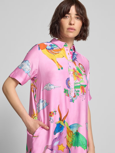 Frauenmodel trägt Knielanges Hemdblusenkleid aus Viskose im Allover-Look von Milano Italy in Rosa mit bunten Einhorn- und Wolkenmotiven, gerader Schnitt, Knopfleiste, Rückenlänge bei Größe 36: 104 cm, Brustweite 53 cm, Ärmellänge 26 cm, Nahaufnahme Oberkörper.