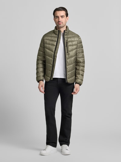 Männermodel trägt Regular Fit Steppjacke mit Stehkragen von Tom Tailor in Oliv, uni, langarm, Reißverschluss, Ganzkörperansicht von vorne.