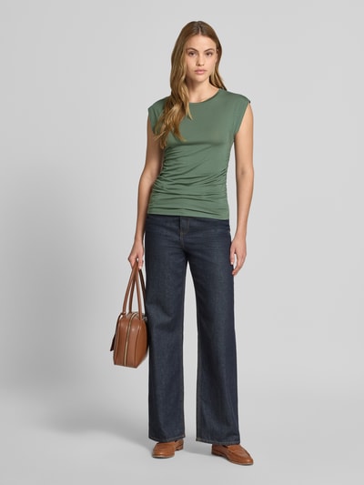 Frauenmodel trägt Slim Fit T-Shirt aus Lyocell-Mix Modell 'AVASARAH' von Vero Moda, Damen T-Shirt mit Optik: Unifarben, seitliche Raffungen, Rundhals, Ärmelform: Kurzarm, Ganzkörperansicht von vorne.