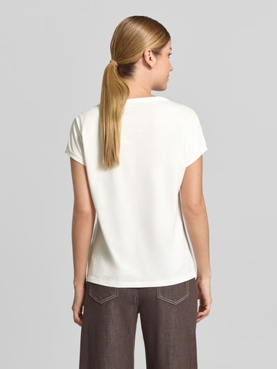 Vrouwenmodel draagt t-shirt uit puur katoen van Marc Cain, getailleerd met ronde hals, elastische mouwboordjes, ruglengte maat 36: 59 cm. Ganzlichaamsaanzicht achteraan.