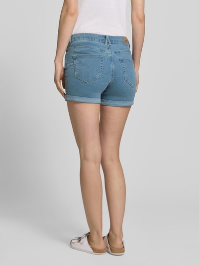 Vrouwenmodel draagt Regular Fit Jeansshorts uit katoenmix model 'LUNA' van Vero Moda, denimlook, lichtblauw, labelpatch, 5-pocketmodel, met riemlussen, knoop- en ritssluiting, korte omslag aan de pijpen, achteraanzicht volledig lichaam