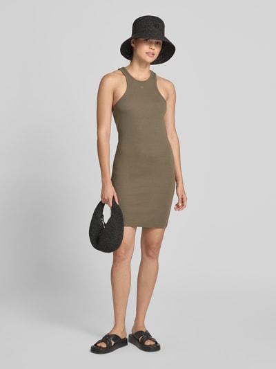 Frauenmodel trägt Slim Fit Kleid aus Viskose-Mix von Anine Bing in Khaki mit Logo-Stitching, Rundhalsausschnitt, Ärmelloses-Design, Ganzkörperansicht von vorne.