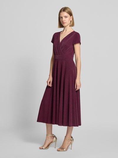 Frauenmodel trägt Tailliertes Cocktailkleid mit V-Ausschnitt von Vera Mont in dunklem Beerenrot mit leichter Struktur, Ganzkörperansicht von vorne.