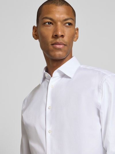 Männermodel trägt weißes Slim Fit Businesshemd mit extra langem Arm von Jake*s, glatte Oberfläche, Nahaufnahme Oberkörper.