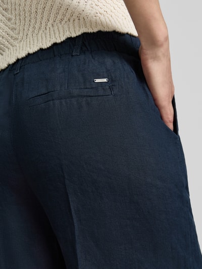 Frauenmodel trägt Leinenshorts mit Eingrifftaschen von Christian Berg Woman, dunkles Reines Leinen, Regular-Fit, Detailaufnahme Rückansicht.