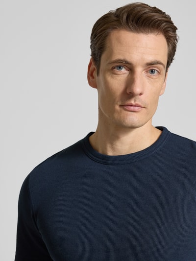 Männermodel trägt Regular Fit T-Shirt aus Baumwoll-Mix von Tom Tailor in Dunkelblau, unifarben, Piqué-Textur, Nahaufnahme Oberkörper.
