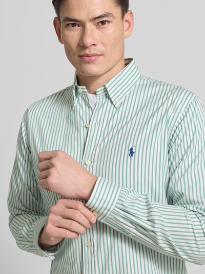 Männermodel trägt Custom Fit Freizeithemd mit Button-Down-Kragen von Polo Ralph Lauren, grüne und weiße Streifen, Reine Baumwolle, Nahaufnahme Oberkörper. Rückenlänge 84 cm, Schulterbreite 44 cm, Ärmellänge 65 cm, Label-Stitching, Knopfleiste.