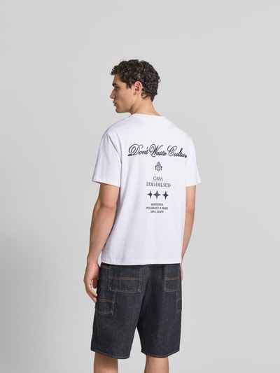 Männermodel trägt Relaxed Fit T-Shirt aus reiner Baumwolle von Don’t Waste Culture mit Rückendruck, Kurzärmelig, Weiß, Rückansicht, Ganzkörperansicht.