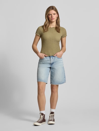 Frauenmodel trägt Slim Fit T-Shirt mit Strukturmuster Modell 'Alora' von Noisy May in Olivgrün, elastischer Material-Mix, Ganzkörperansicht von vorne.