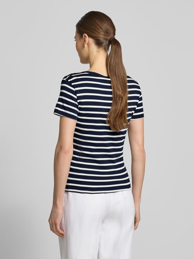 Frauenmodel trägt Slim Fit T-Shirt aus reiner Baumwolle von Tommy Hilfiger in unifarbenem Look mit Logo-Detail, Zierknöpfe, U-Boot-Ausschnitt, kurzarm, glatte Webware, Ganzkörperansicht Rückansicht.