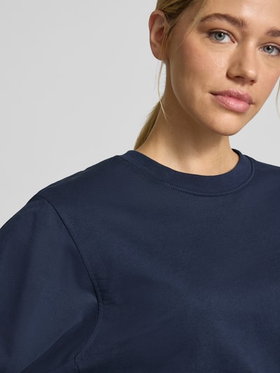 Vrouwenmodel draagt donkerblauw sweatshirt met ronde hals van biologisch katoen, relaxed fit, model 'Saida' van FREE/QUENT, close-up bovenlichaam
