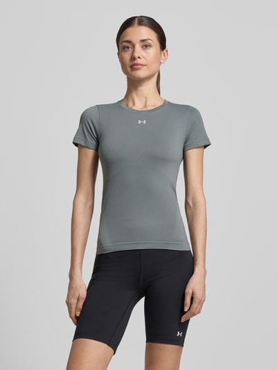 Vrouwenmodel draagt T-Shirt met Rundhalsausschnitt und Logo van Under Armour, slim fit, grijs met logo, stretch, materiaal-mix; vooraanzicht, bovenlichaam close-up.