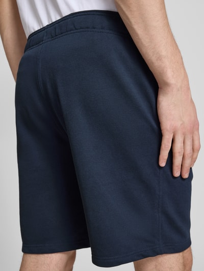 Männermodel trägt Shorts mit elastischem Bund und Label-Stitching von CHAMPION, katoenmix, regular fit, donkerblauw, detailopname rugaanzicht.