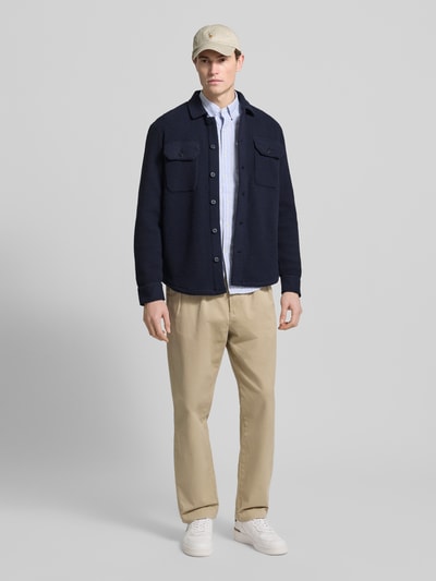 Männermodel trägt Hemdjacke mit Kentkragen von Polo Ralph Lauren, Regular-Fit, Knopfleiste, Brusttaschen, beige Hose, Ganzkörperansicht von vorne. Rückenlänge bei Größe M: 72 cm.