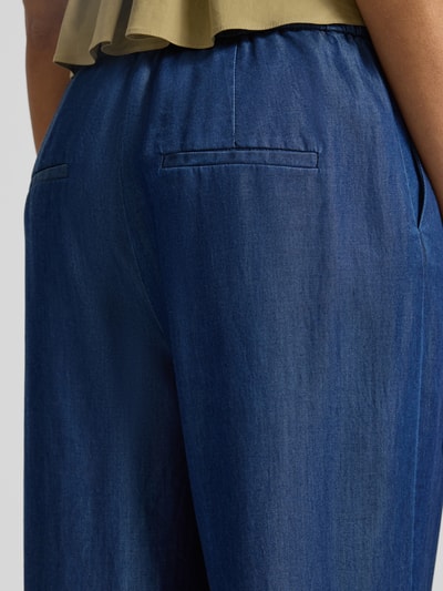 Kobieta nosi Wide Leg Jeans aus Lyocell od s.Oliver BLACK LABEL, denim, szerokie nogawki, kieszenie, materiał lyocell, detal z tyłu, zbliżenie tylnej części