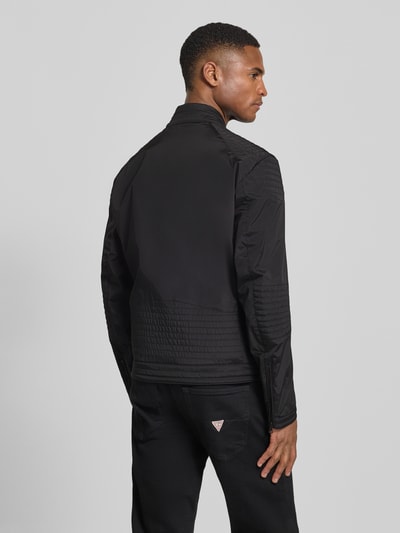 Männermodel trägt schwarze Jacke mit Zweiwege-Reißverschluss Modell 'Thayer' von Blauer Usa, gerader Schnitt, Rückansicht Ganzkörperansicht.