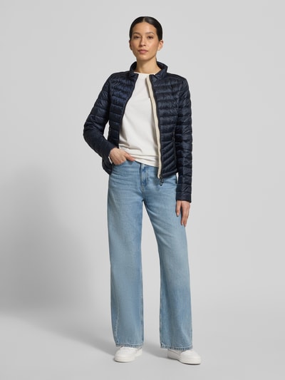 Frauenmodel trägt Steppjacke mit Stehkragen von Gil Bret in Dunkelblau, Zweiwege-Reißverschluss, Reißverschlusstaschen, körpernahe Passform, Rückenlänge 56 cm, Schulterbreite 39 cm, Brustweite 47 cm, Ärmellänge 66 cm, Ganzkörperansicht von vorne.