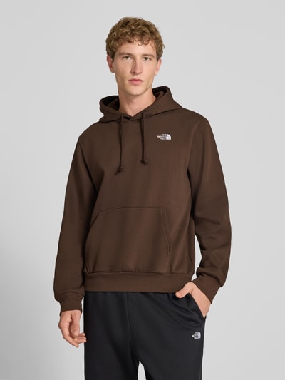 Männermodel trägt Regular Fit Hoodie mit Känguru-Tasche Modell "EVOLUTION" von The North Face aus katoenmix in bruin met gestikt logo op de borst, Heren hoodie, Ganzkörperansicht von vorne