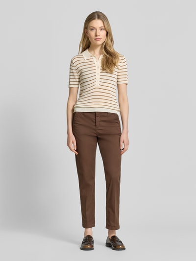 Frauenmodel trägt Straight Fit Chino in verkürzter Passform von MAC, braun, Baumwoll-Mix, Eingriff- und Gesäßtaschen, Ganzkörperansicht von vorne.