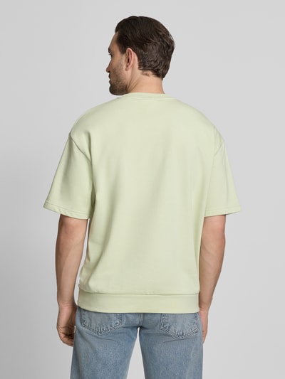 Mannmodel draagt Oversized T-shirt met ronde hals van Lindbergh, katoenmix, labeldetail, ruglengte maat M 70 cm. Ganzkörperansicht Rückansicht.