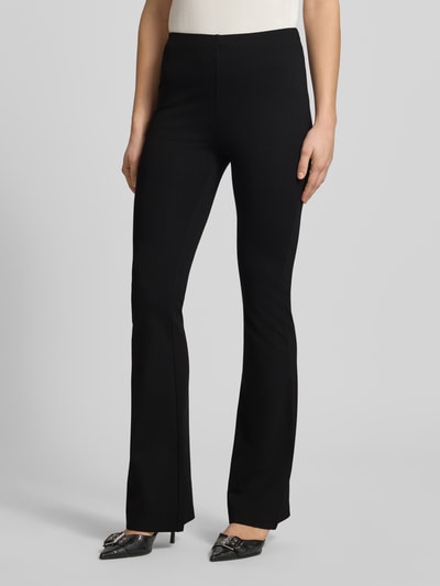 Frauenmodel trägt Flared Fit Stoffhose aus Viskose-Mix von Review in Schwarz, elastischer pasek, krój flared fit, Szerokość w rozmiarze S: 37 cm, długość nogawki wewnętrznej w rozmiarze S: 85 cm, zbliżenie na dolną część ciała, Ganzkörperansicht von vorne.