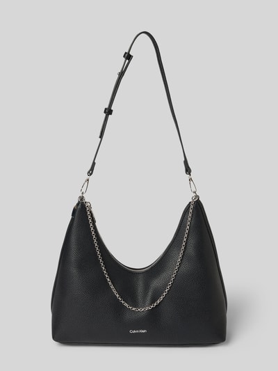 Produktfoto, Handtasche mit Label-Detail von CK Calvin Klein in Schwarz mit Kettendetail, sichtbare strukturierte Oberfläche, Hauptfach z zamkiem, regulowany pasek na ramię, wewnętrzna kieszeń z zamkiem, Szerokość w rozmiarze 1: 24 cm, długość: 27 cm, głębokość: 11 cm, długość paska: 68 cm