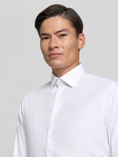 Männermodel trägt Regular Fit Business-Hemd mit Kentkragen von Christian Berg Men, Baumwoll-Mix mit Stretch-Anteil, Nahaufnahme Oberkörper.