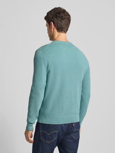 Męski model nosi Strickpullover mit Label-Stitching od Lerros, bawełna, regular fit, turkus, widok całej sylwetki z tyłu.
