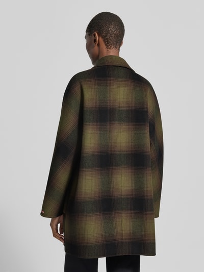 Vrouwenmodel draagt lange wollen jas van MAX&Co., Model 'GIURIA', all-over motief, regular fit, reverskraag, dubbele knoopsluiting, logodetail, klepzakken, webware van zuivere wol, kleuren groen en zwart, textuur zacht geweven, Ganzkörperaanzicht achteraan.