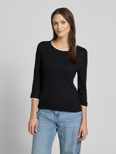Frauenmodel trägt schwarzes Longsleeve mit 3/4-Arm Modell 'Kalora' von Someday, Viskose-Elasthan-Mix, Slim-Fit, Rundhalsausschnitt, Rückenlänge bei Größe 36: 56 cm, Nahaufnahme Oberkörper.