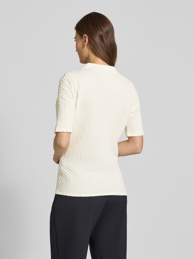 Frauenmodel trägt Regular Fit Poloshirt mit V-Ausschnitt von Betty Barclay aus Baumwoll-Mix mit Stretch-Anteil, Strukturmuster, cremefarben, Rückenlänge bei Größe 36: 59 cm, Ganzkörperansicht Rückansicht.