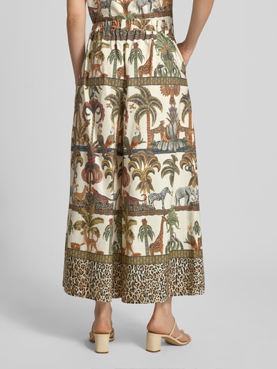 Frauenmodel trägt Wide Leg Hose im Allover-Look von MORE & MORE, cremefarbene Baumwolle mit Wildlife-Print, elastischer Bund, Detailaufnahme Rückansicht.