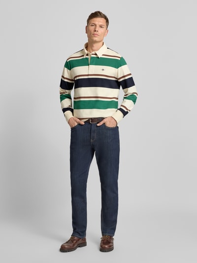 Męski model nosi Bluza z kołnierzykiem polo i wyhaftowanym logo od Gant, bawełna, krój regular fit, guziki zakryte, widok z przodu całej sylwetki.