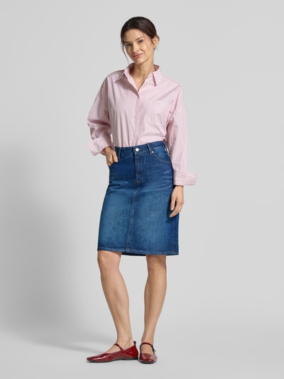 Frauenmodel trägt körpernahen Jeansrock aus reiner Baumwolle von Tommy Hilfiger, Optik: Unifarben, knielang, 5-Pocket-Design, Ganzkörperansicht von vorne.