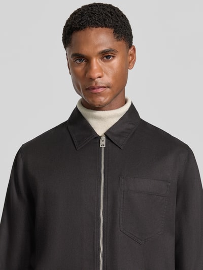 Männermodel trägt Regular Fit Bomberjacke / Blouson aus Lyocell-Baumwoll-Mix Modell 'Enasoz' von HUGO in Schwarz, Nahaufnahme Oberkörper. Herren Bomberjacke / Blouson von HUGO.
