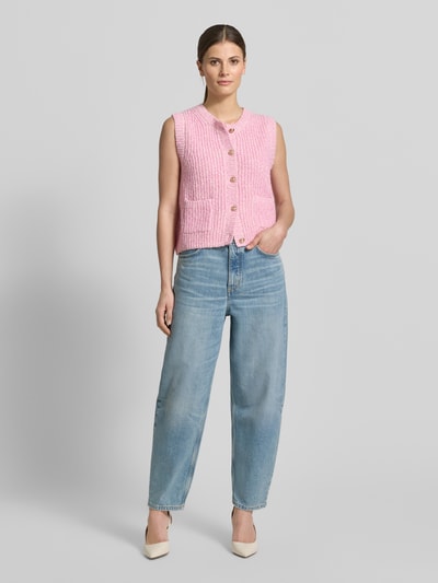 Frauenmodel trägt Strickweste Melange Effekt mit Schmuckknopf von Christian Berg Woman, Rosa mit gerippten Abschlüssen, Jeans, Ganzkörperansicht von vorne.