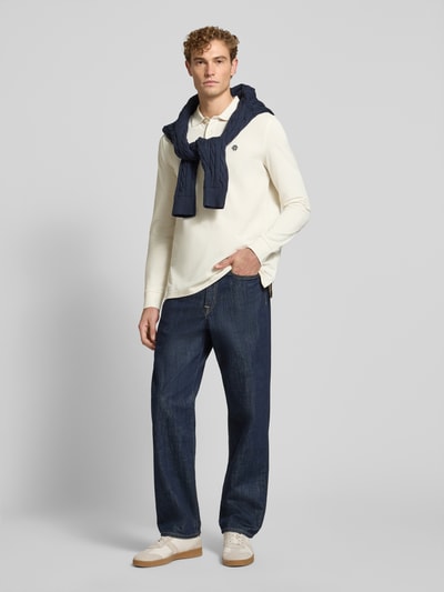 Mannelijk model draagt Regular Fit poloshirt uit puur katoen van MCNEAL, polokraag met knoopsluiting, labelstitching, shirt met lange mouwen, donkerblauwe broek, ruglengte maat M 73 cm, effen design, Ganzkörperansicht von voren.