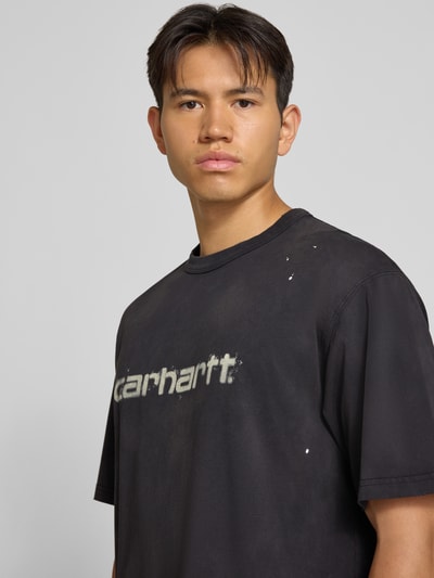 Męski model nosi Regular Fit T-Shirt aus reiner Baumwolle Model 'Painter' von Carhartt Work In Progress, czarny z detalem z logo, t-shirt z bawełny, Długość tyłu w rozmiarze M: 72 cm, Nahaufnahme Oberkörper.