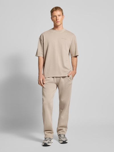 Männermodel trägt Sweathose mit elastischem Bund von Pegador aus Baumwoll-Mix, Lockerer-Schnitt, Label-Stitching, Eingrifftaschen, Ganzkörperansicht von vorne.